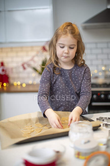Mädchen steht in Küche und backt Weihnachtsplätzchen. — Stockfoto