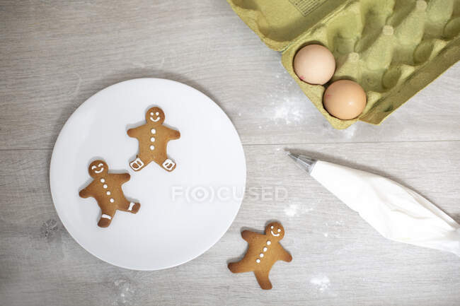 High angle close up of Gingerbread Men on a white plate. — Stock Photo