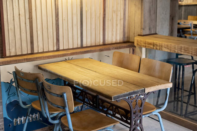 Восстановленные деревянный и металлический винтажный стол и стулья в пабе. — стоковое фото