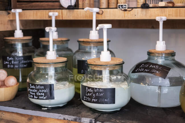 Close up de dispensadores de frascos de vidro de produtos de beleza em uma loja de alimentos integrais sem resíduos. — Fotografia de Stock