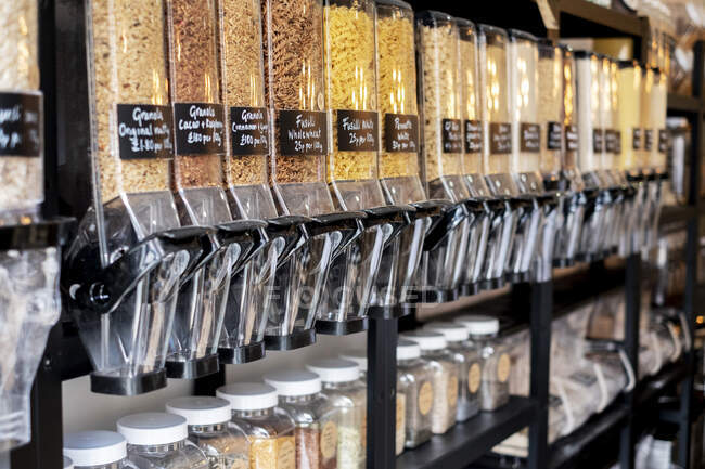 Gros plan des distributeurs d'aliments avec des pâtes séchées dans un magasin d'aliments complets sans déchets. — Photo de stock