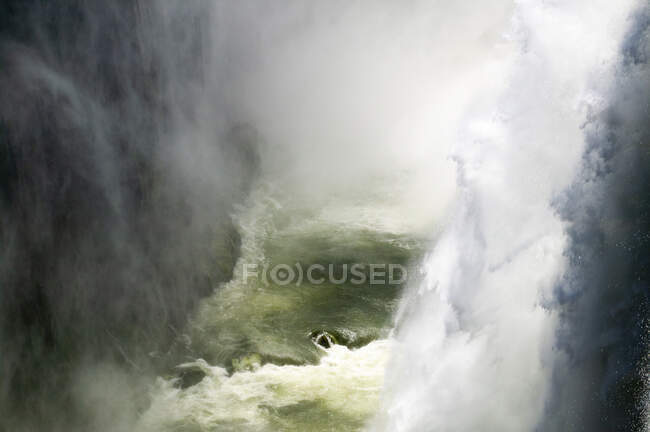 Blick aus der Vogelperspektive auf Wasser, das die Victoria Falls hinunterstürzt, Sambia. — Stockfoto