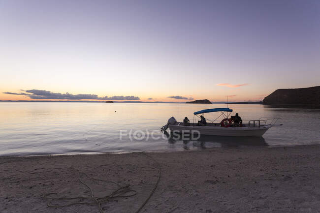 Imbarcazione a motore ormeggiata vicino spiaggia al tramonto, Mare di Cortes — Foto stock