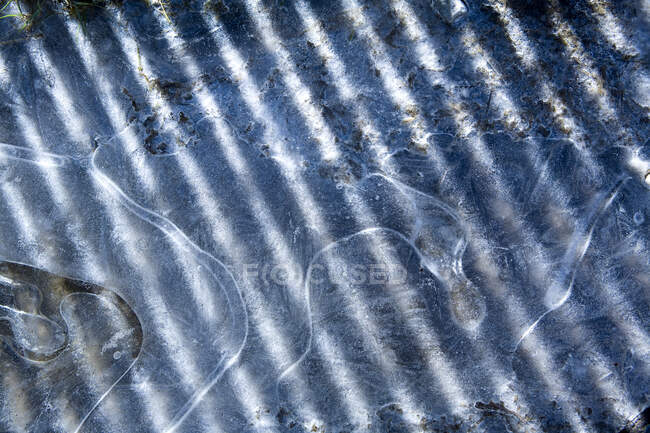 Glace, contours de l'eau gelée, ombres et lumière du soleil. — Photo de stock