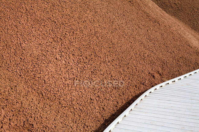 A wooden walkway, observation platform and red ochre slope in the Painted Hills, Oregon — Stock Photo