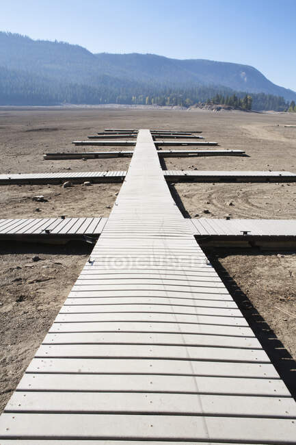 Planks laid out as walkways, jetties on flat dry desert soil, open space. — Stock Photo