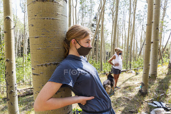 Adolescente usando máscara COVID-19 na floresta de árvores Aspen — Fotografia de Stock