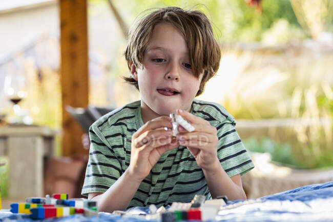 Семирічний хлопчик грає з будівельними блоками на терасі — стокове фото