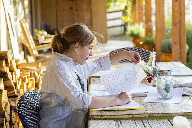 Teenagermädchen schreibt bei Sonnenuntergang auf der Terrasse. — Stockfoto