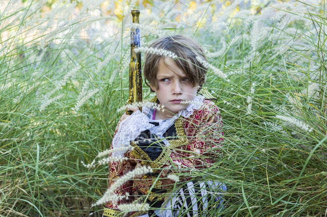 Молодий хлопчик, одягнений як пірат, тримає довгий пістолет . — стокове фото