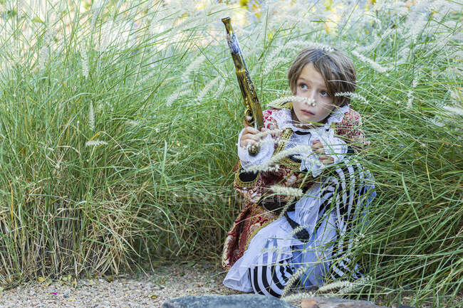 Молодий хлопчик, одягнений як пірат, тримає довгий пістолет . — стокове фото