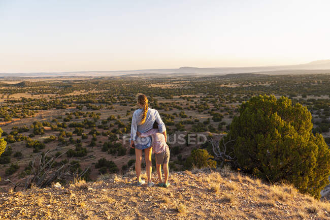 Adolescente embrassant son frère cadet dans le bassin de Galisteo, Santa Fe, NM. — Photo de stock