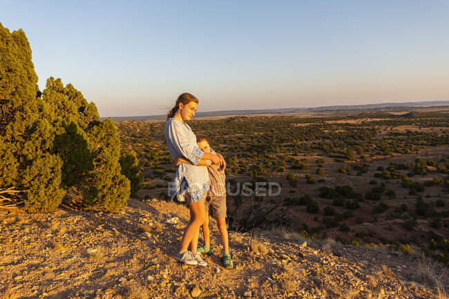 Adolescente che abbraccia il fratello minore nel bacino del Galisteo, Santa Fe, NM. — Foto stock
