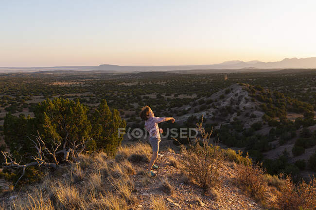 Niño con vistas al increíble paisaje de la cuenca del Galisteo, Santa Fe, NM - foto de stock