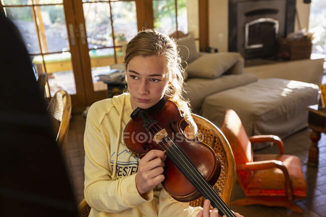 Adolescente arrancando cuerdas de su violín en casa - foto de stock