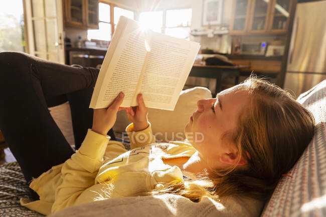 Teenager-Mädchen liest Buch zu Hause im Morgenlicht — Stockfoto