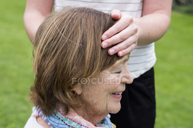 Reiki therapist with a client in a therapy session touching meridian points on the body. — Stock Photo