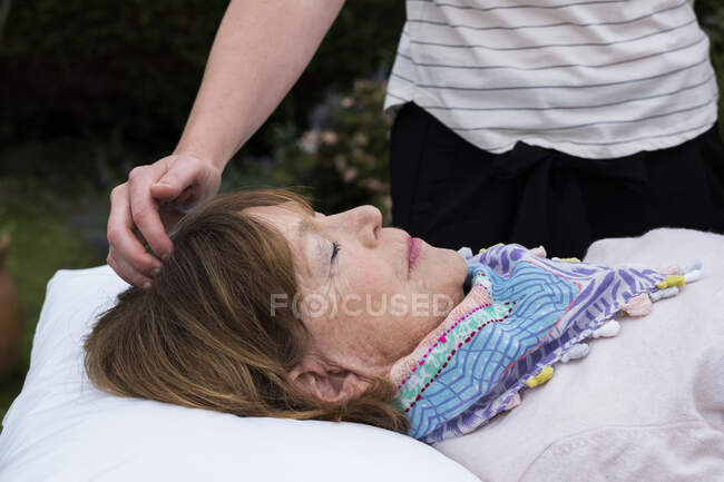 Рейки-терапевт с клиентом на сеансе терапии касаются меридианов точек на теле. — стоковое фото