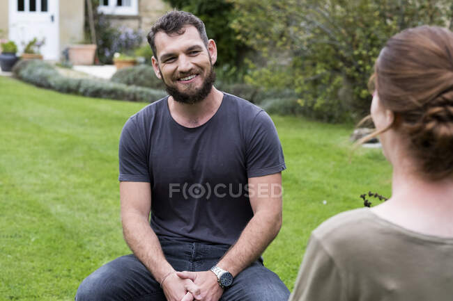 Мужчина и женщина-терапевт сидят в саду, как сеанс терапии — стоковое фото