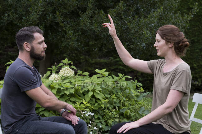Man and female therapist in a garden, sharing techniques of EFT — Stock Photo
