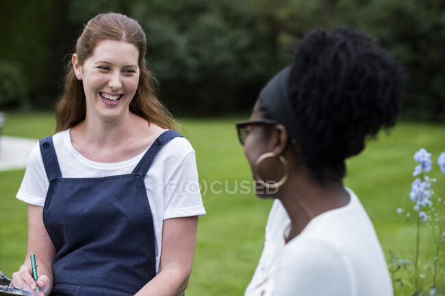 Woman and female therapist talking in a garden. — Stock Photo