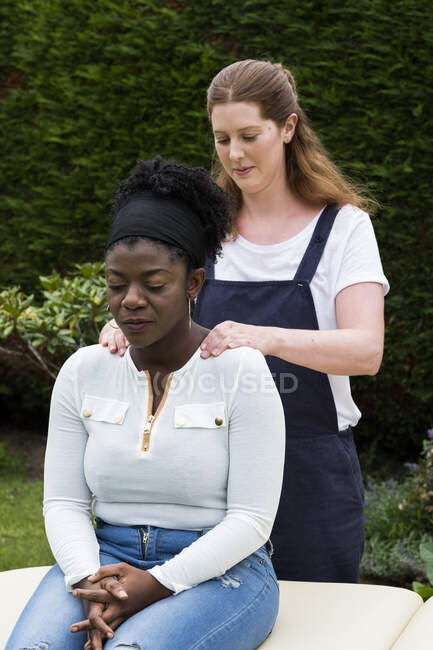 Terapista toccare le spalle di un cliente in sessione di terapia all'aperto — Foto stock