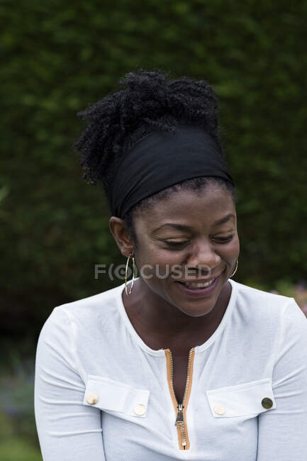 Retrato de mulher negra sentada em um jardim, sorrindo durante sessão de terapia alternativa. — Fotografia de Stock