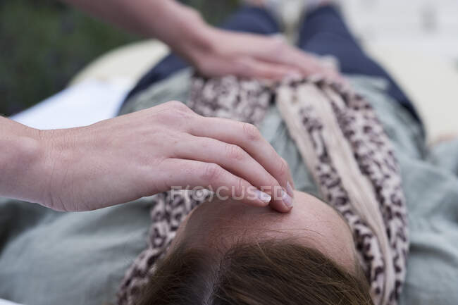 Mulher em um sofá e um terapeuta tocando sua cabeça e estômago — Fotografia de Stock