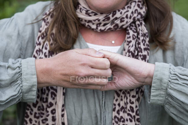Frau hält ihre Hände, die Finger zusammengerollt und zupackend. — Stockfoto