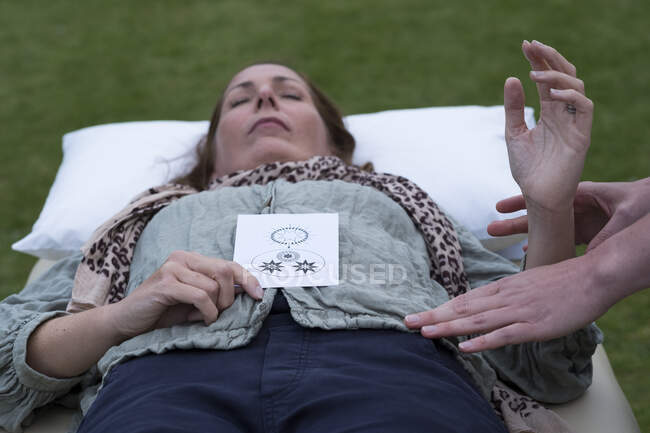 Mujer en un sofá y terapeuta tocando su cuerpo - foto de stock