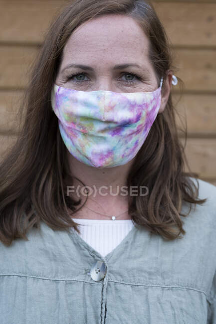 Portrait of woman with long brunette hair wearing face mask — Stock Photo