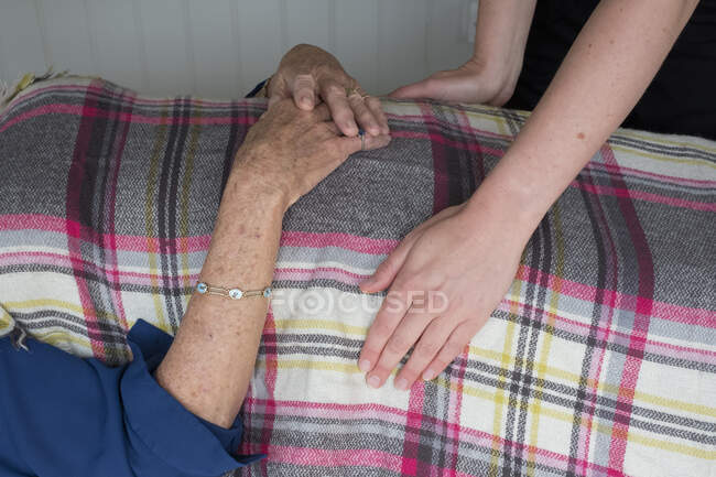 Woman on a couch a therapist placing hands on her head and stomach, — Stock Photo
