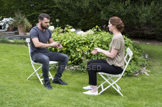 Man and female therapist engaged in alternative therapy session in a garden. — Stock Photo