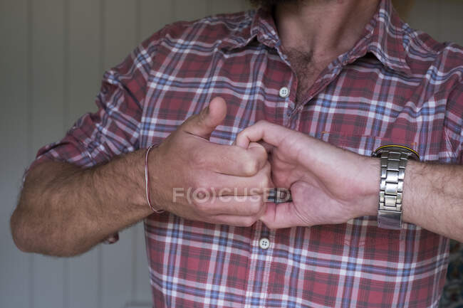 Uomo con le mani strette afferrando le dita arricciate. — Foto stock