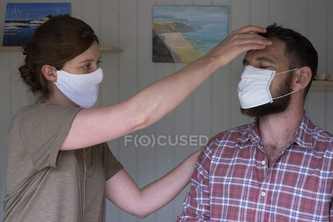Terapeuta y cliente en mascarillas faciales, en una sesión de terapia alternativa. - foto de stock
