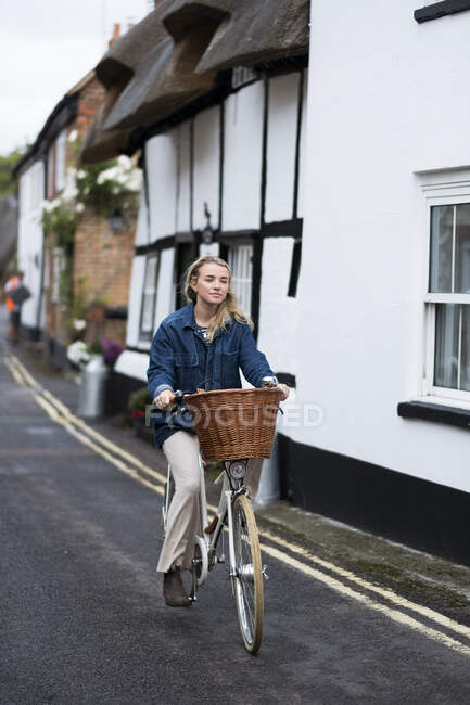 Молодая блондинка едет по деревенской улице. — стоковое фото