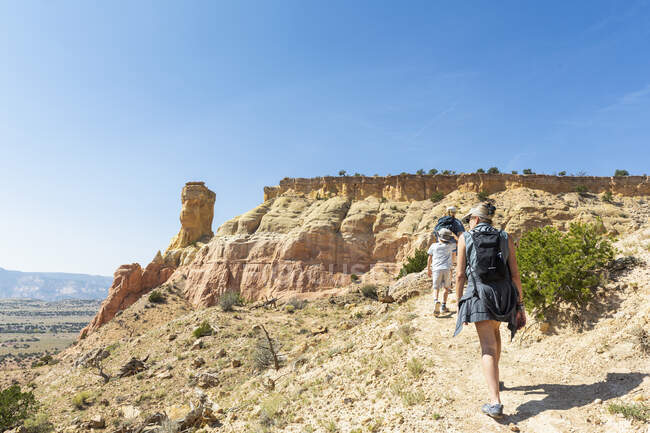 Trois personnes, randonnée en famille sur un sentier à travers un paysage protégé de canyon — Photo de stock