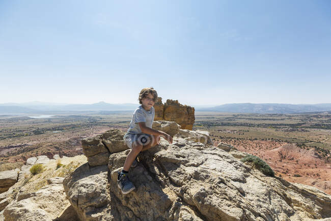 Niño caminando a la cima de la roca de la chimenea hito en un paisaje de cañón protegido - foto de stock