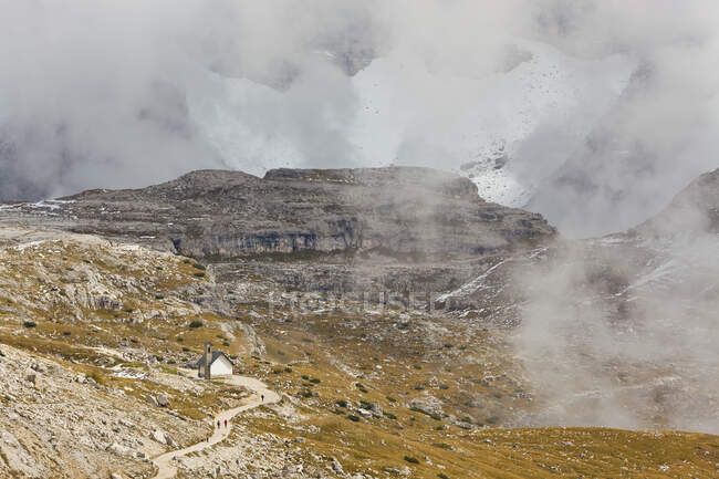 Sendero de montaña y pequeña capilla, Parque Natural Dolomiti di Sesto - foto de stock