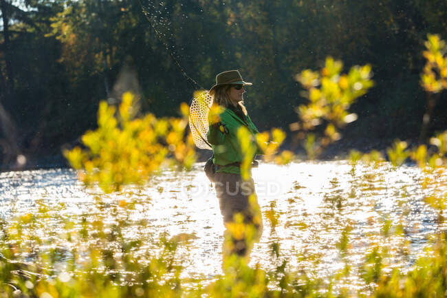 Fly fisherwoman casting and fishing on river, British Colombia, Canada. — Stock Photo