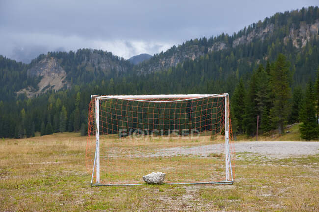 Fußballtor und flaches Feld in einem Tal in den Dolomiten. — Stockfoto