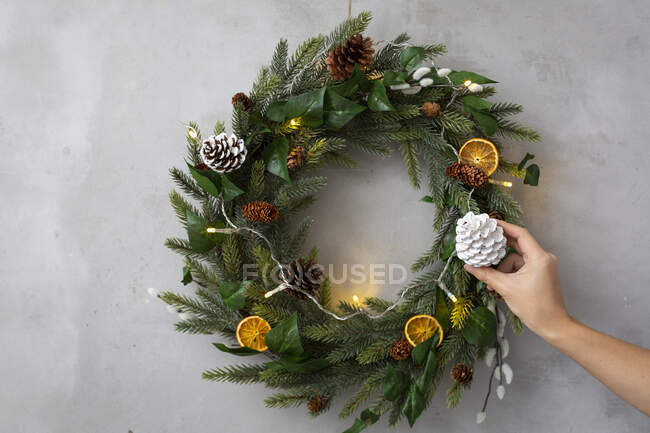 Christmas decorations, close up of person decorating Christmas wreath with ornaments. — Stock Photo