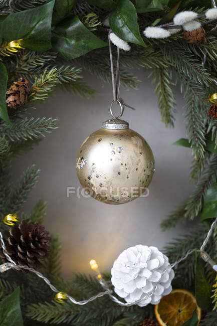 Christmas decorations, close up of golden bauble and white pine cone on Christmas wreath. — Stock Photo