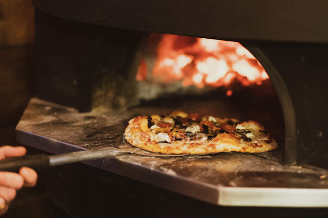 Close up of pizza in a wood-fired oven in a restaurant. — Stock Photo