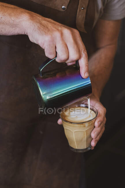 Nahaufnahme eines Baristas, der einen Café Latte einschenkt. — Stockfoto