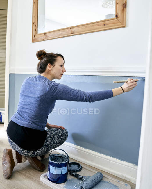 Женщина рисует стену дома — стоковое фото