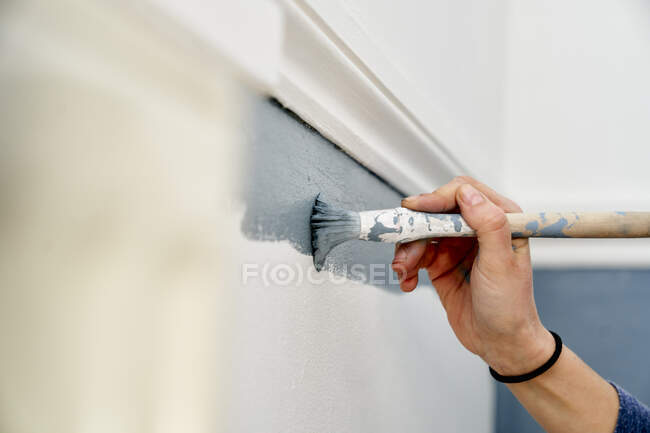 Крупним планом рука використовує пензлик для фарбування стіни — стокове фото