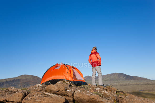 Женщина, стоящая у палатки, Исландия — стоковое фото