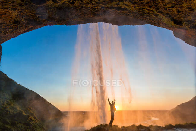 Uomo dietro la cascata Seljalandsfoss, Islanda meridionale, Islanda — Foto stock