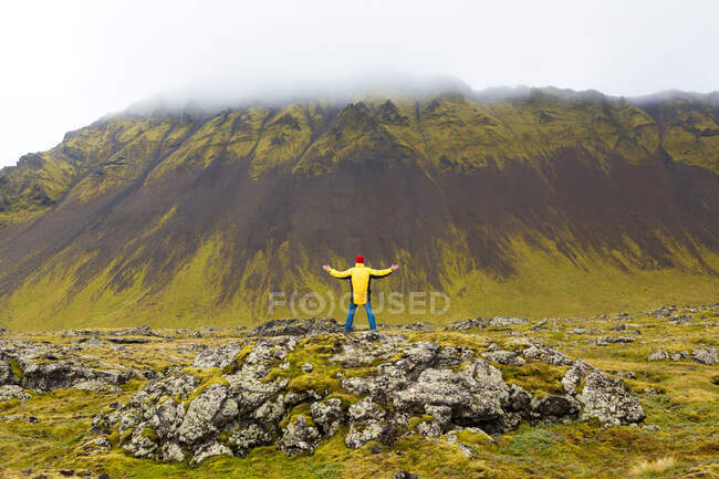 Hombre de pie sobre rocas, Península de Snaefellsnes, Islandia Occidental - foto de stock